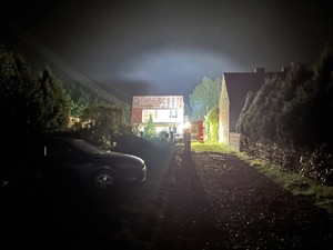 zdjęcie przedstawia dom w nocy, oświetlony na potrzeby czynności wykonywanych przez policjantów