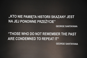 tablica z napisem &quot;Kto nie pamięta historii skazany jest na jej ponowne przeżycie&quot; - George Santayana. Pod napisem tkest przetłumaczony na język angielski.
