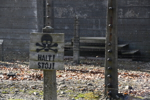 drewniana tabliczka na ogrodzeniu obozu z napisem Halt - stój