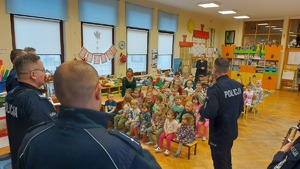 na zdjęciu widoczni policjanci wraz z dziećmi w trakcie wizyty w przedszkolu