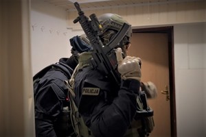 Zdjęcie. Widoczni umundurowani uzbrojeni policjanci