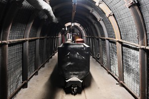 Zdjęcie przedstawia wagonik kolejki górniczej w korytarzu imitującym wnętrze kopalni