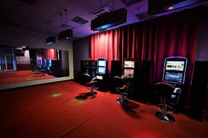 Zdjęcie przedstawia wnętrze salonu gier, na zdjęciu widać trzy maszyny do gier.
