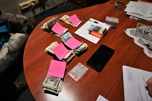 Zdjęcie przedstawia stół a na nim pieniądze, dowód osobisty oraz telefon.