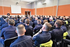 Zdjęcie. Grupa umundurowanych policjantów na sali