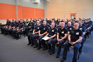 Zdjęcie. Grupa umundurowanych policjantów na sali