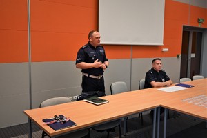 Zdjęcie. Dwaj umundurowani policjanci na sali