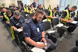 Zdjęcie. Grupa umundurowanych policjantów na sali podczas testu wiedzy
