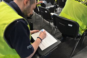 Zdjęcie. Umundurowany policjant na sali podczas testu wiedzy