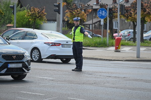 Zdjęcie. Umundurowany policjant kierujący ruchem na skrzyżowaniu