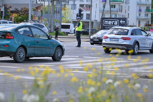 Zdjęcie. Umundurowany policjant kierujący ruchem na skrzyżowaniu