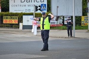 Zdjęcie. Umundurowany policjant kierujący ruchem na skrzyżowaniu