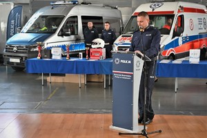Zdjęcie. Umundurowany lektor policji na hali sportowej