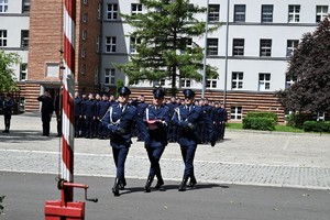 zdjęcie przedstawia zdjęcie przedstawia policjantów pocztu flagowego maszerujących w stronę masztu