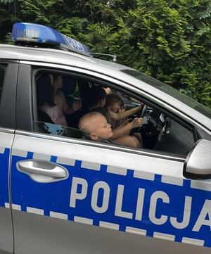 Zdjęcie. Dzieci w policyjnym radiowozie