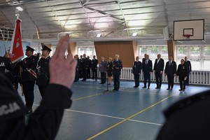 Zdjęcie. I Zastępca Komendanta Wojewódzkiego odczytuje rotę ślubowania na sali, widoczni inni umundurowani policjanci i goście uroczystości