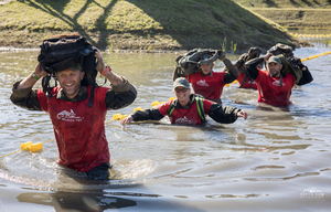 Zdjęcie. Grupa zawodników pokonuje przeszkodę wodną