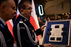Zdjęcie przedstawia dwóch policjantów, jeden trzyma dyplom