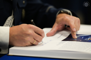 Komendant Wojewódzki Policji w Katowicach podpisuje pamiątkową księgę