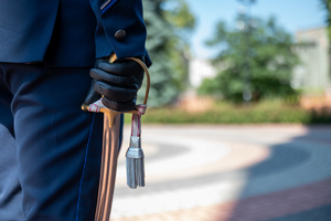 Zdjęcie kolorowe na którym widoczny jest policjant trzymający szablę w ręce