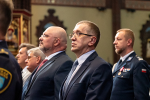 kolorowe zdjęcie przedstawiające stojących mężczyzn ubranych w garnitury