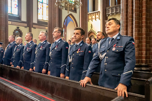 kolorowe zdjęcie policjantów korpusu oficerów starszych stojących w ławce w bazylice