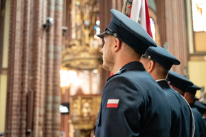 kolorowe zdjęcie przedstawiające policjantów fotografowanych z profilu