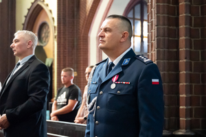 kolorowe zdjęcie policjanta korpusu oficerów starszych stojącego w ławce bazyliki