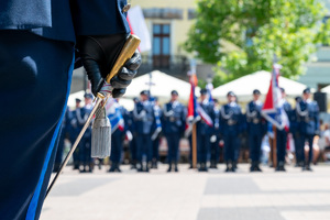 kolorowe zdjęcie dłoni policjanta w której trzymana jest szabla