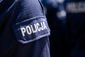 kolorowe zdjęcie munduru przedramienia policjanta z napisem Policja