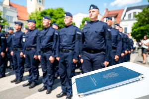 kolorowe zdjęcie Konstytucji RP położonej na mównicy, w tle policjanci
