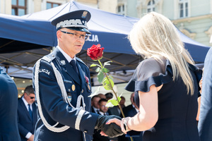 Generał Policji wręcza kobiecie róże