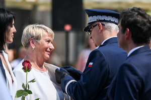Kolorowe zdjęcie przedstawiające Generała Wojewódzkiej Policji w Katowicach odznaczającego kobietę
