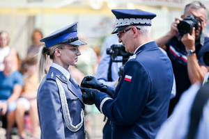 kolorowe zdjęcie przedstawiające Generała Wojewódzkiej Policji w Katowicach wręczającego odznaczenie policjantce