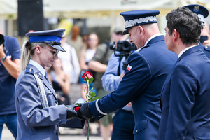 kolorowe zdjęcie przedstawiające Generała Komendy Głównej Policji wręczającego róże policjantce