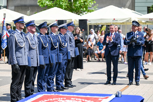 kolorowe zdjęcie przedstawiające policjantów stojących w szeregu oraz gości honorowych obchodów Święta Policji