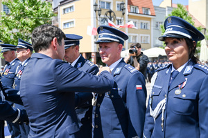 kolorowe zdjęcie przedstawiające mężczyznę w garniturze odznaczającego Oficera Policji