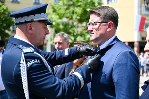 kolorowe zdjęcie przedstawiające Generała Policji odznaczającego mężczyznę w garniturze