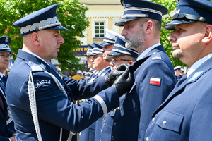 kolorowe zdjęcie przedstawiające Generała Policji odznaczającego Oficera Policji