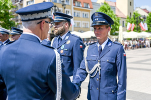 kolorowe zdjęcie przedstawiające Generała Policji gratulującego policjantce