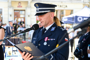 kolorowe zdjęcie przedstawiające Oficera Policji przemawiającego z mównicy