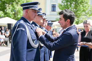 kolorowe zdjęcie przedstawiające mężczyznę odznaczającego Oficera Policji