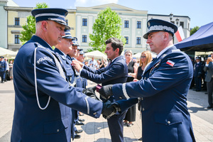 kolorowe zdjęcie przedstawiające Generała Policji wręczającego odznaczenie Oficerowi Policji
