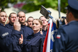 kolorowe zdjęcie przedstawiające policjantkę, w tle widać sztandar