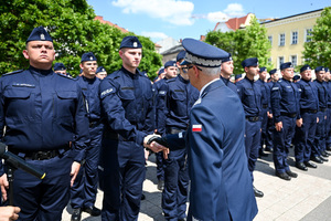 kolorowe zdjęcie przedstawiające Generała Policji składającego gratulacje policjantom