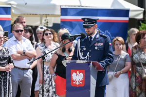 kolorowe zdjęcie przedstawiające Oficera Policji podczas przemówienia
