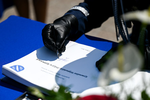kolorowe zdjęcie przedstawiające dłonie Generała Policji składającego podpis na dokumencie