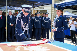kolorowe zdjęcie przedstawiające Generała Policji podchodzącego do sztandaru