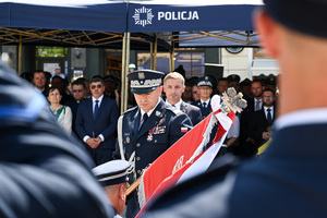 kolorowe zdjęcie Generała Policji na tle sztandaru oraz gości honorowych obchodów Święta Policji