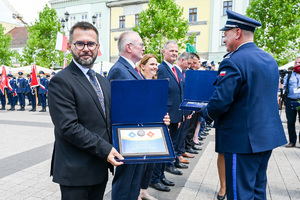 Kolorowe zdjęcie przedstawiające gości honorowych Święta Policji, prezentujących otrzymane odznaczenia